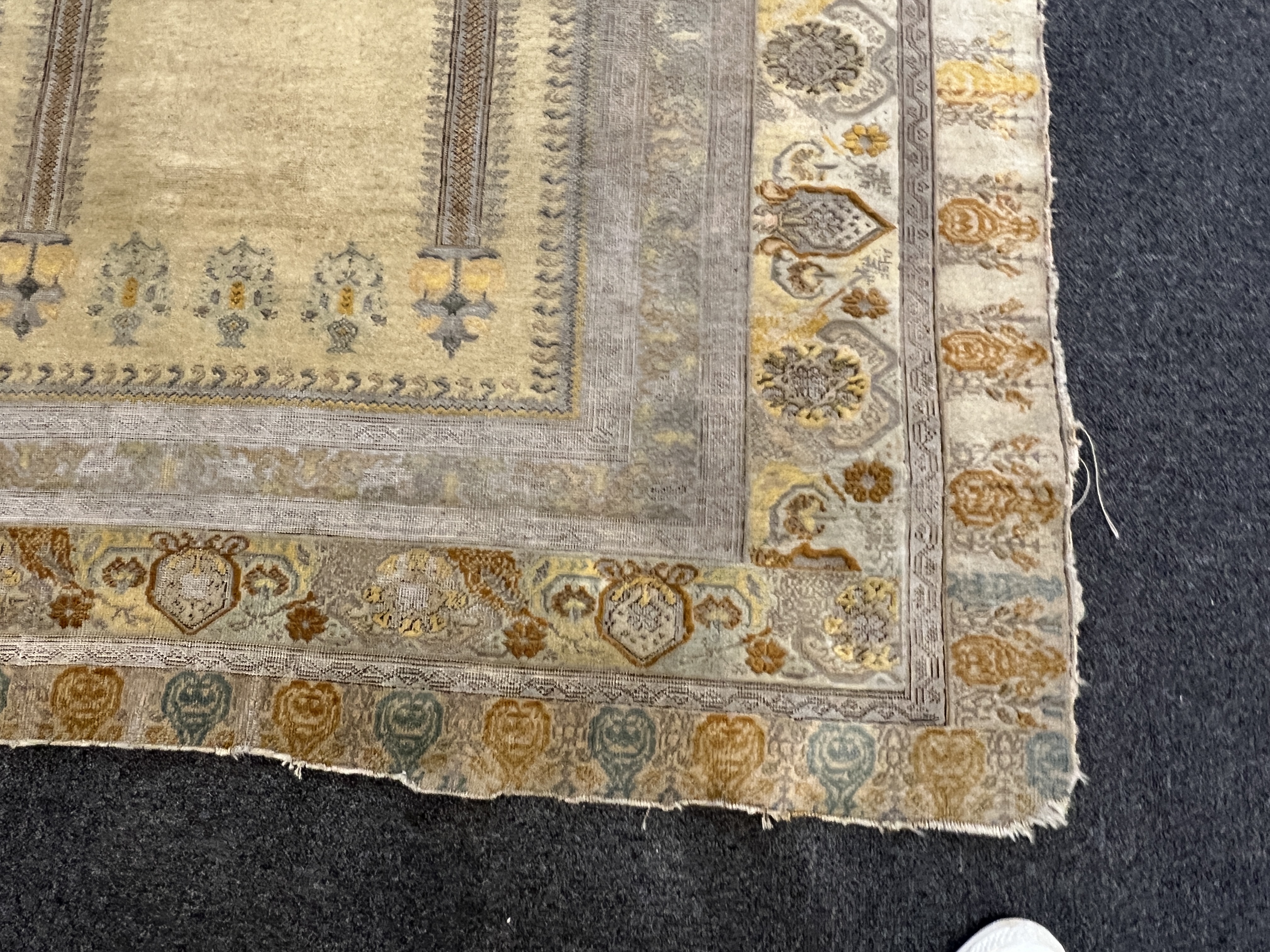 A Turkish silk prayer rug, with mihrab and stylised foliate borders on a gold ground, 185 x 137cm. Condition - the central panel severely worn to the tip of the mirror, lower fringe worn with losses.